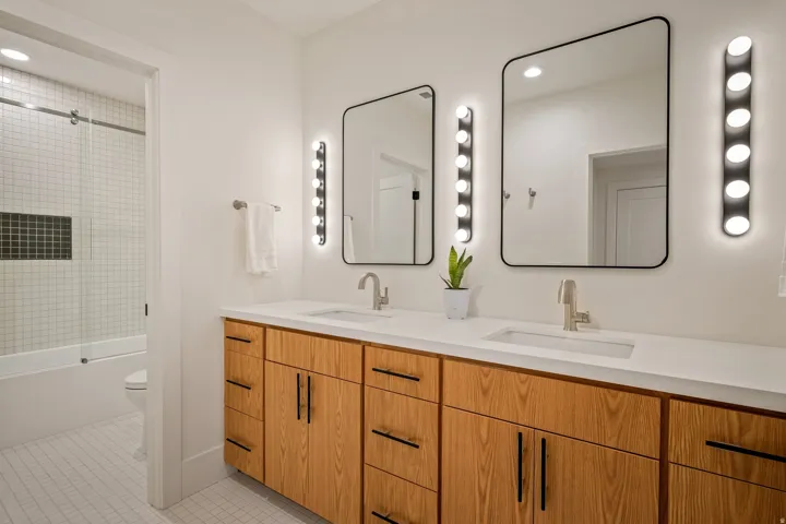 Double vanity featuring wood-finish cabinetry and integrated sinks with brushed nickel faucets