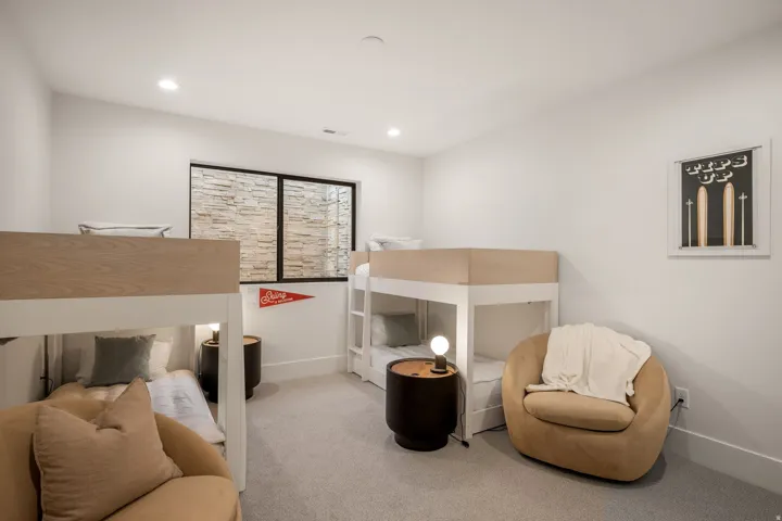 Room featuring light gray carpeting, recessed lighting, and a window with a stone-textured exterior view