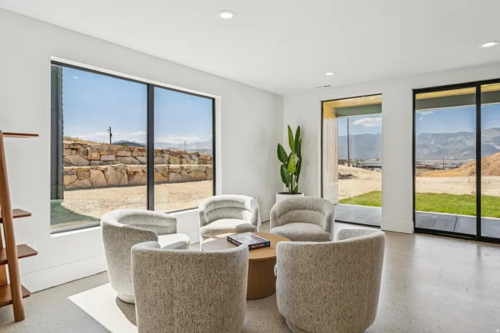 Spacious room featuring multiple large windows, recessed ceiling lighting, a concrete floor, and white painted walls