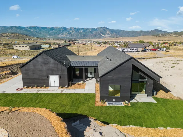 Contemporary black siding exterior with a dark-pitched roof and a contrasting light entry door
