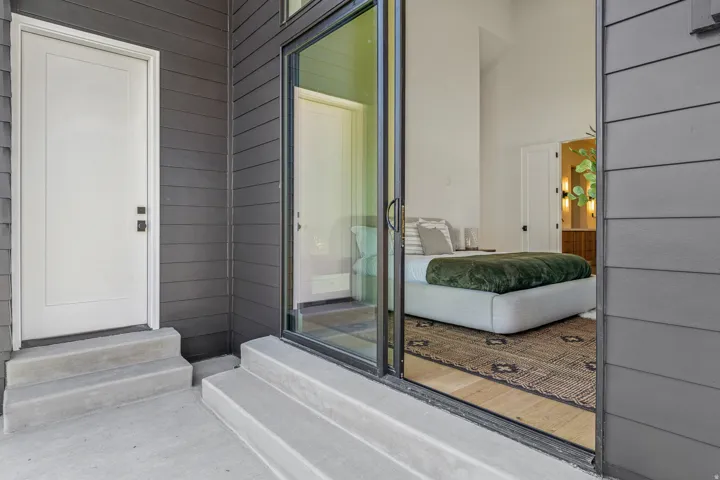 Modern exterior with dark gray horizontal siding and a white entry door