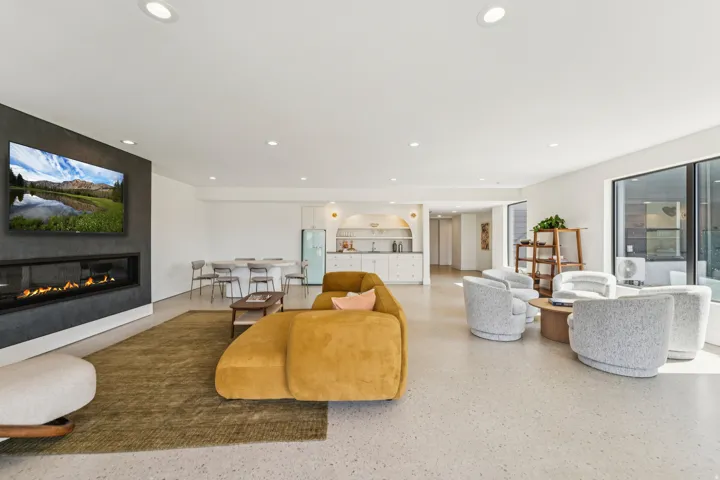 Open-concept interior featuring a built-in linear fireplace with a dark accent wall, recessed lighting, and light-toned terrazzo-style flooring
