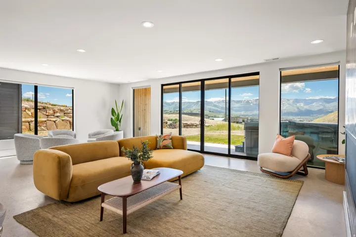 Spacious living area featuring large windows, sliding glass doors, recessed lighting, and hard-surface flooring