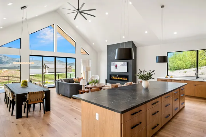 Vaulted ceilings with a ceiling fan and recessed lighting characterize this open-concept living space