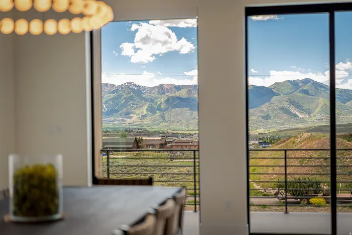 Expansive mountain scenery framed by large windows and glass doors, offering abundant natural light