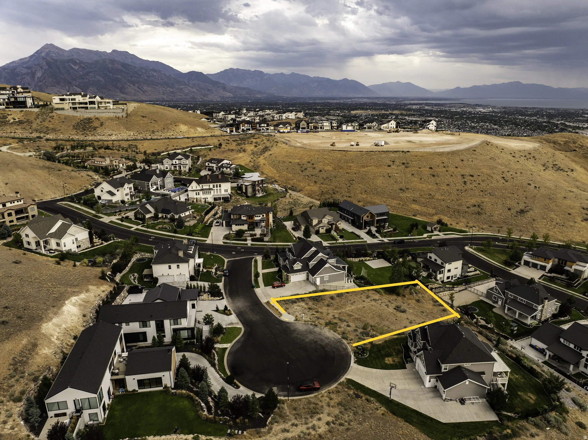 Vacant lot situated in a residential cul-de-sac with surrounding mountainous terrain