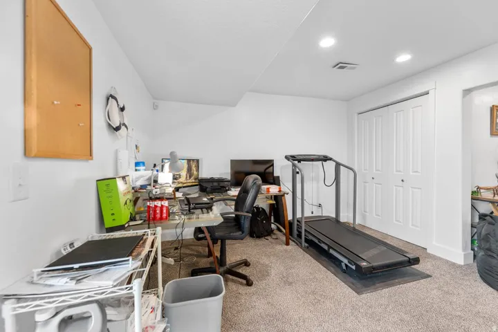 Spacious room featuring neutral carpet flooring, recessed lighting, and white bi-fold closet doors