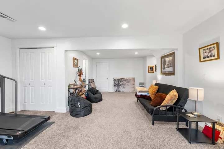 Carpeted interior space featuring white walls, recessed lighting, and white trim