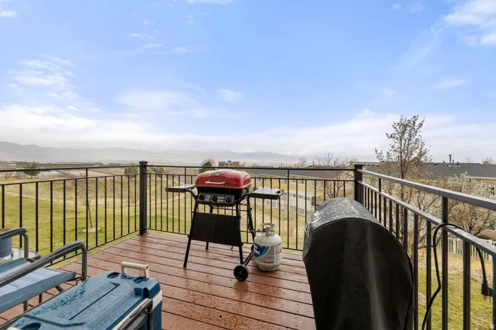 Upper-level deck featuring composite wood-finish flooring and black metal railings