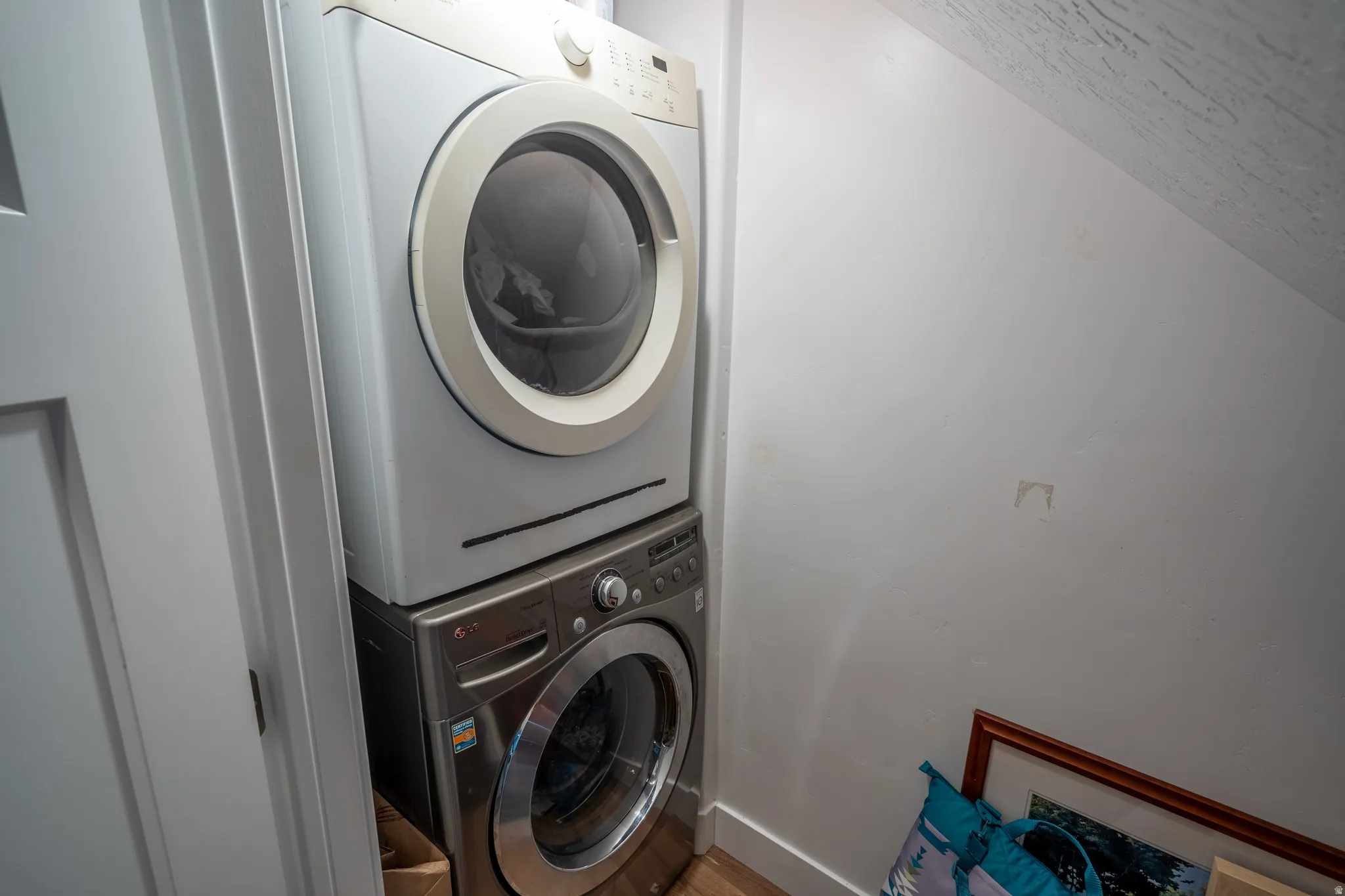 Dedicated laundry area featuring a stacked washer and dryer unit