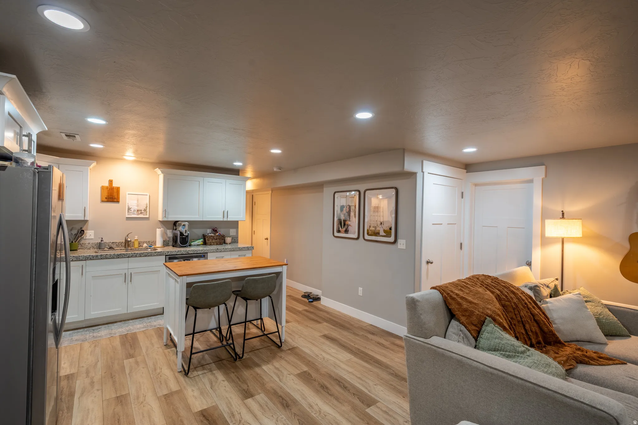 Open concept living space featuring wood-finish flooring, recessed lighting, and a neutral color palette