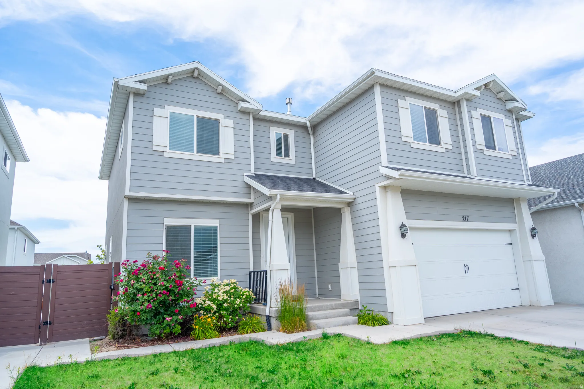 Two-story residential structure featuring light gray siding and white trim