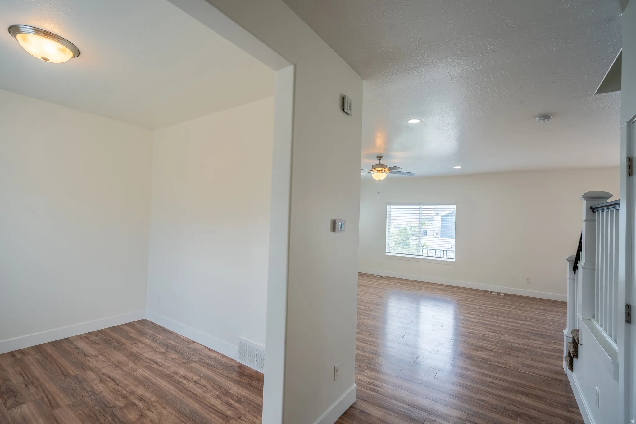 Open-concept interior featuring wood-finish flooring, recessed lighting, and a ceiling fan