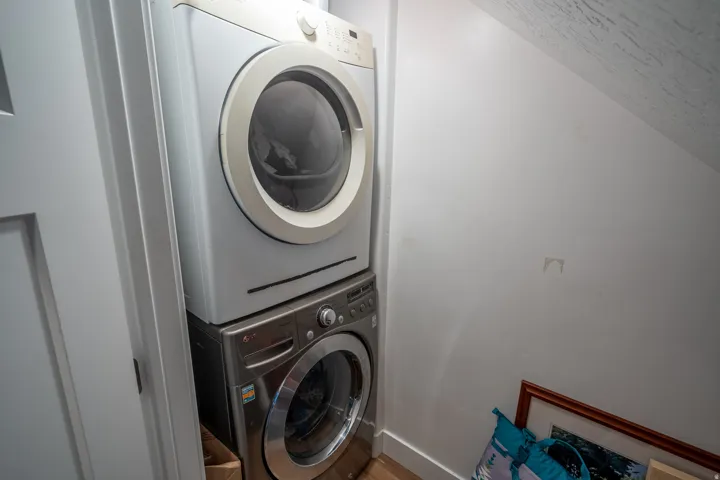 Dedicated laundry area featuring a stacked washer and dryer unit