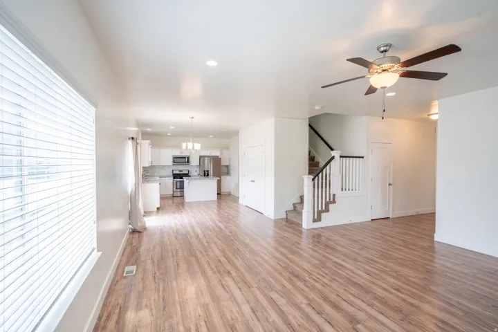 Open-concept living area featuring wood-finish flooring, recessed lighting, and a ceiling fan