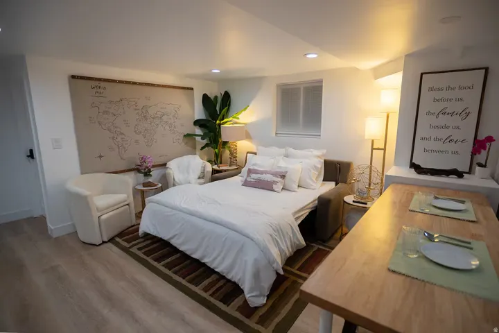 Open-concept room featuring light wood-finish flooring, recessed lighting, and a window with blinds