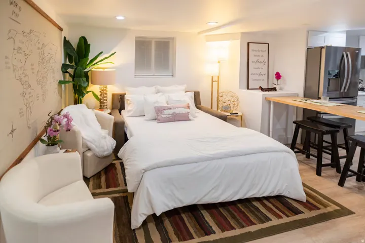 Open-concept living area featuring light wood-finish flooring, recessed lighting, and a kitchen area with stainless steel appliances