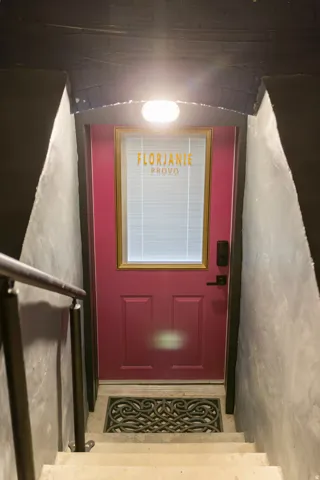 Deep magenta entryway door with a gold-framed window accent