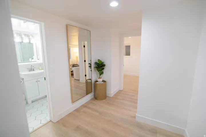 Hallway featuring light wood-finish flooring and recessed ceiling lighting