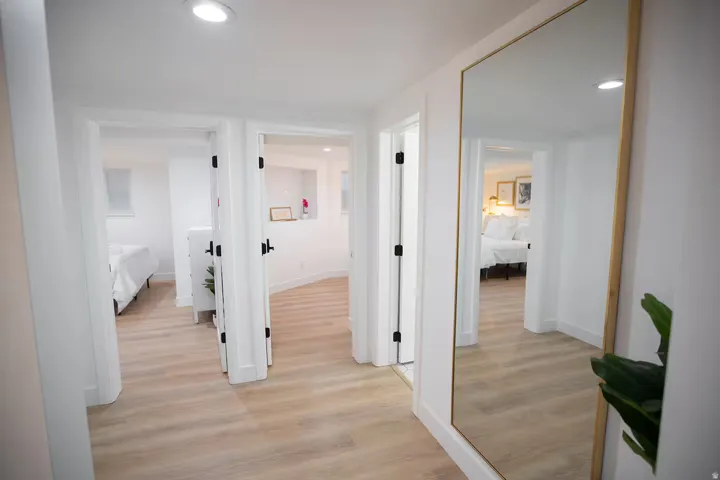 Corridor featuring multiple doorways, recessed lighting, and light wood-finish flooring