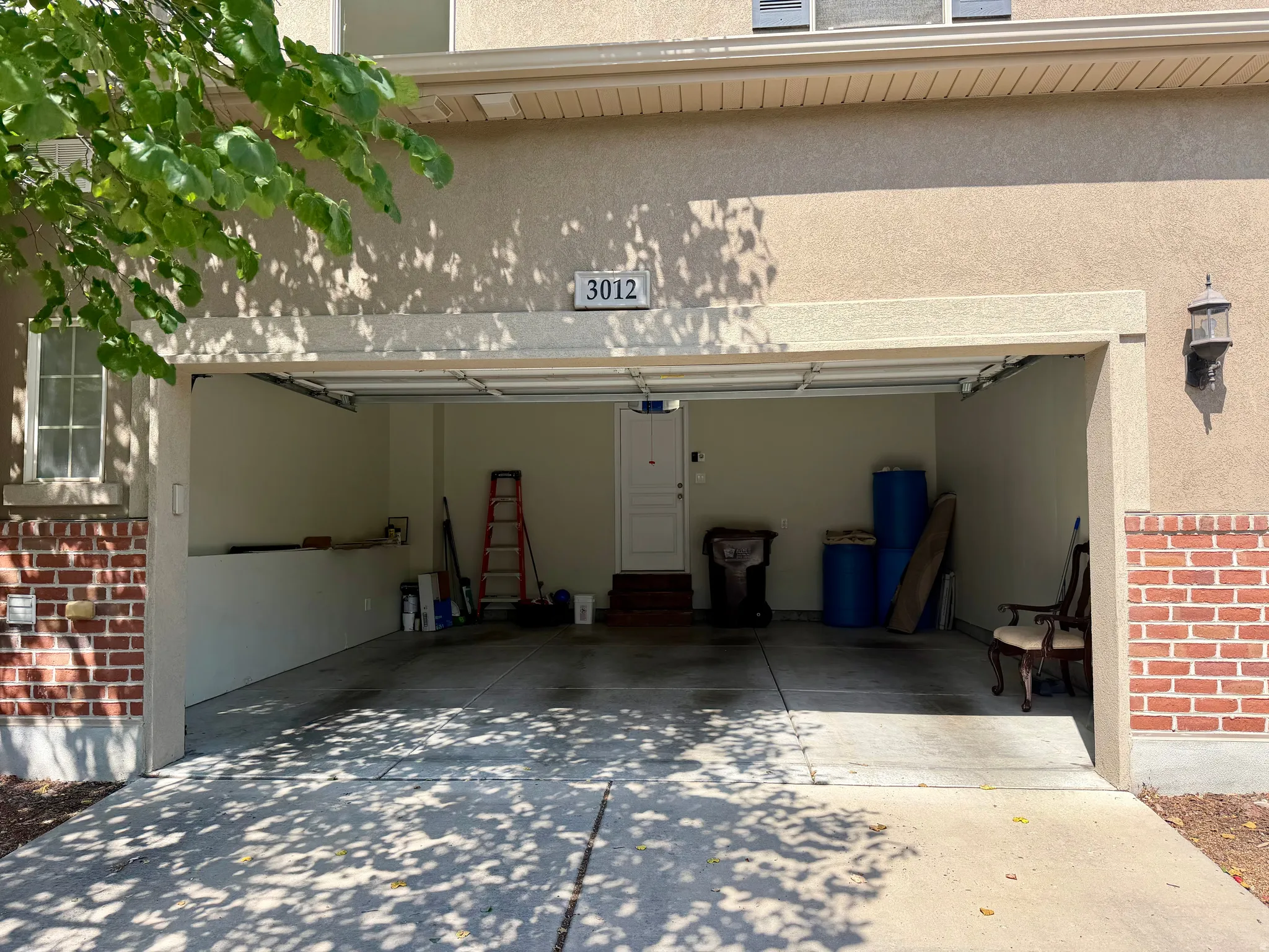 Two-car garage with a concrete floor, interior access door, and integrated wall shelving