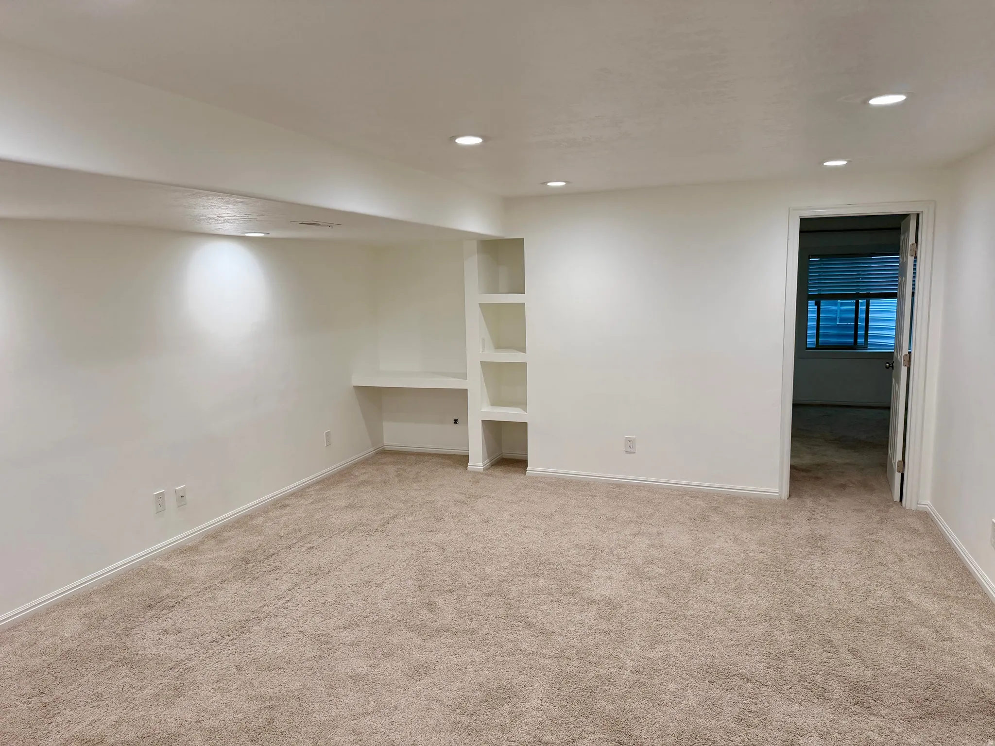 Carpeted interior space featuring white walls and recessed ceiling lighting