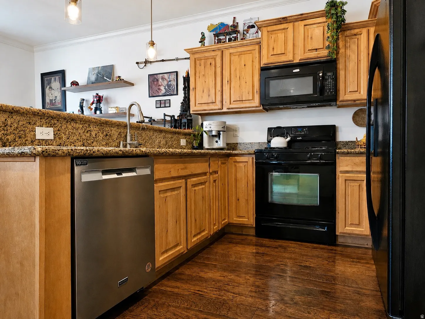 Kitchen featuring wood-finish flooring, light wood cabinetry, stone countertops, stainless steel dishwasher, and black range with coordinating microwave