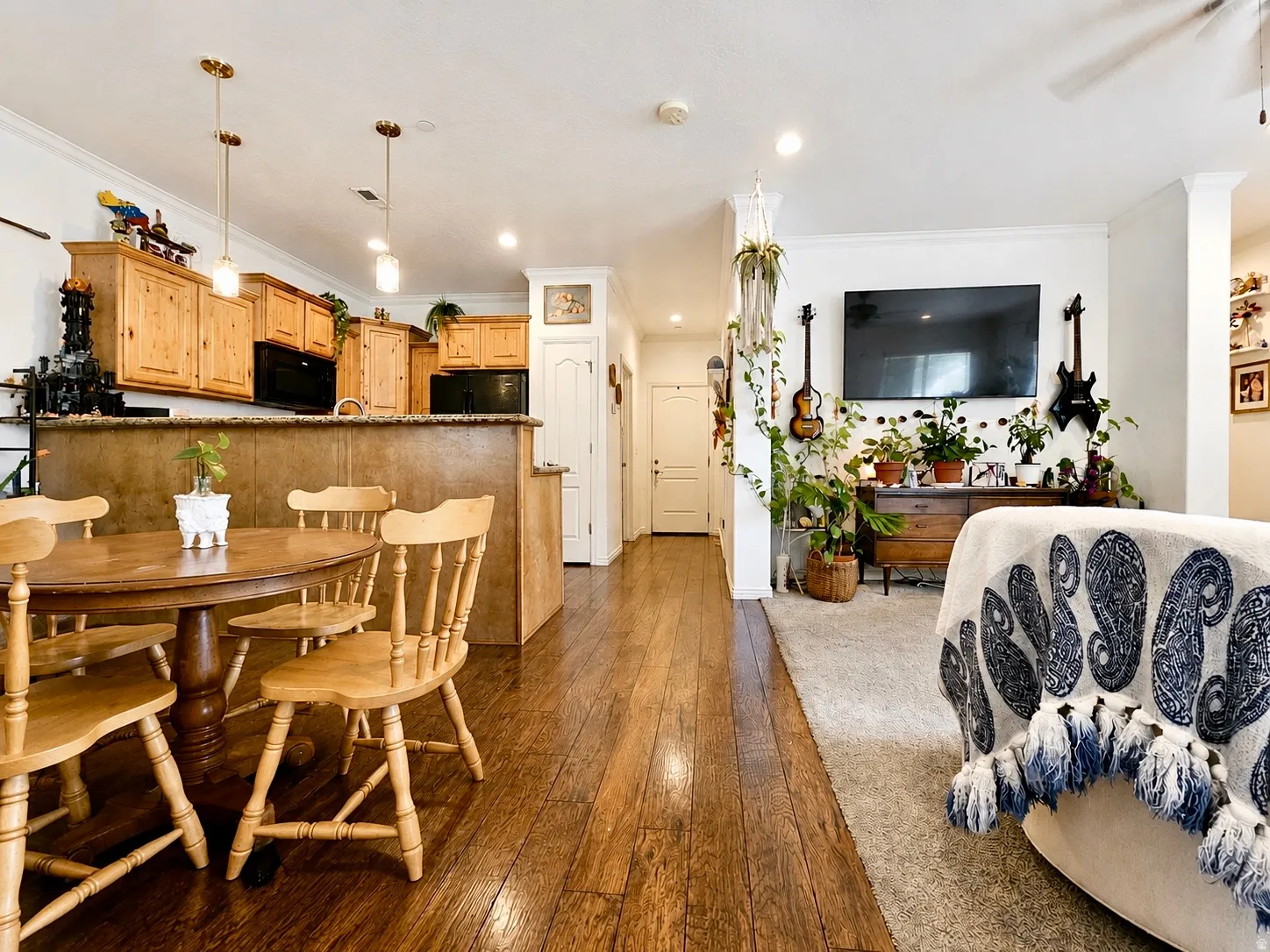 Open-concept living area featuring rich wood-finish flooring, recessed lighting, and a neutral color palette