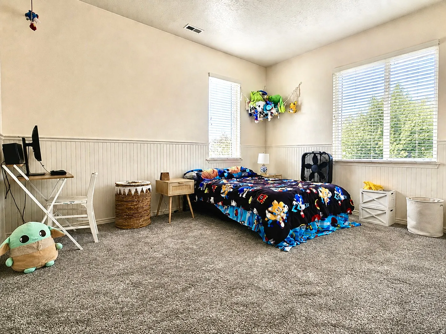 Plush gray carpeting throughout, complemented by white wainscoting paneling