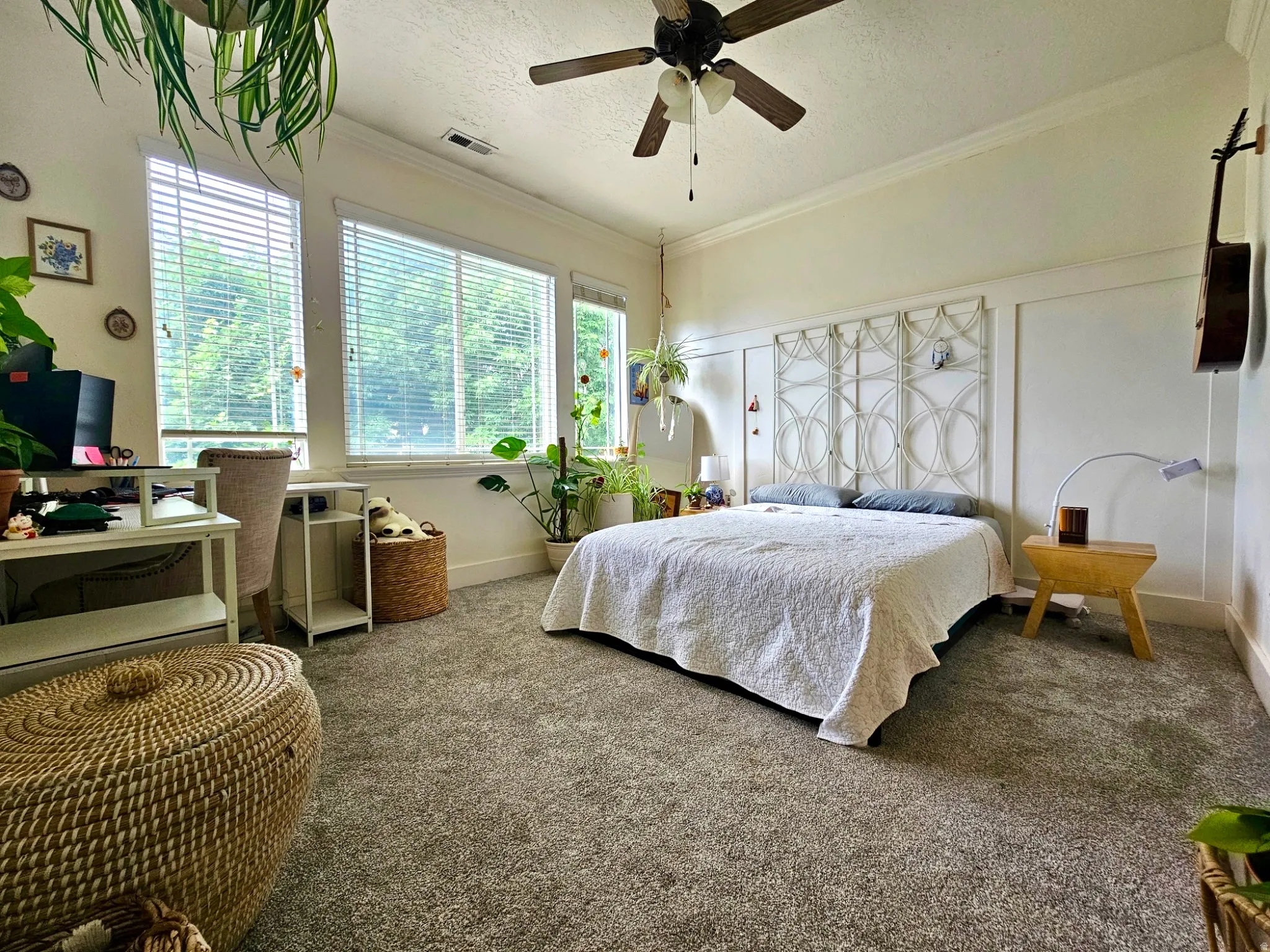 Room featuring broadloom carpeting, extensive natural light from multiple windows with blinds, a ceiling fan, and crown molding