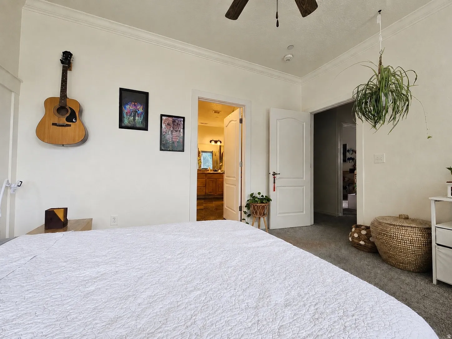 Spacious room featuring neutral-toned walls, crown molding, and a ceiling fan