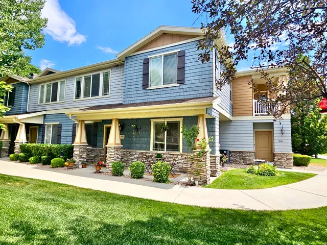 Multi-story townhome exterior featuring blue shake siding, light blue horizontal siding, and tan accents