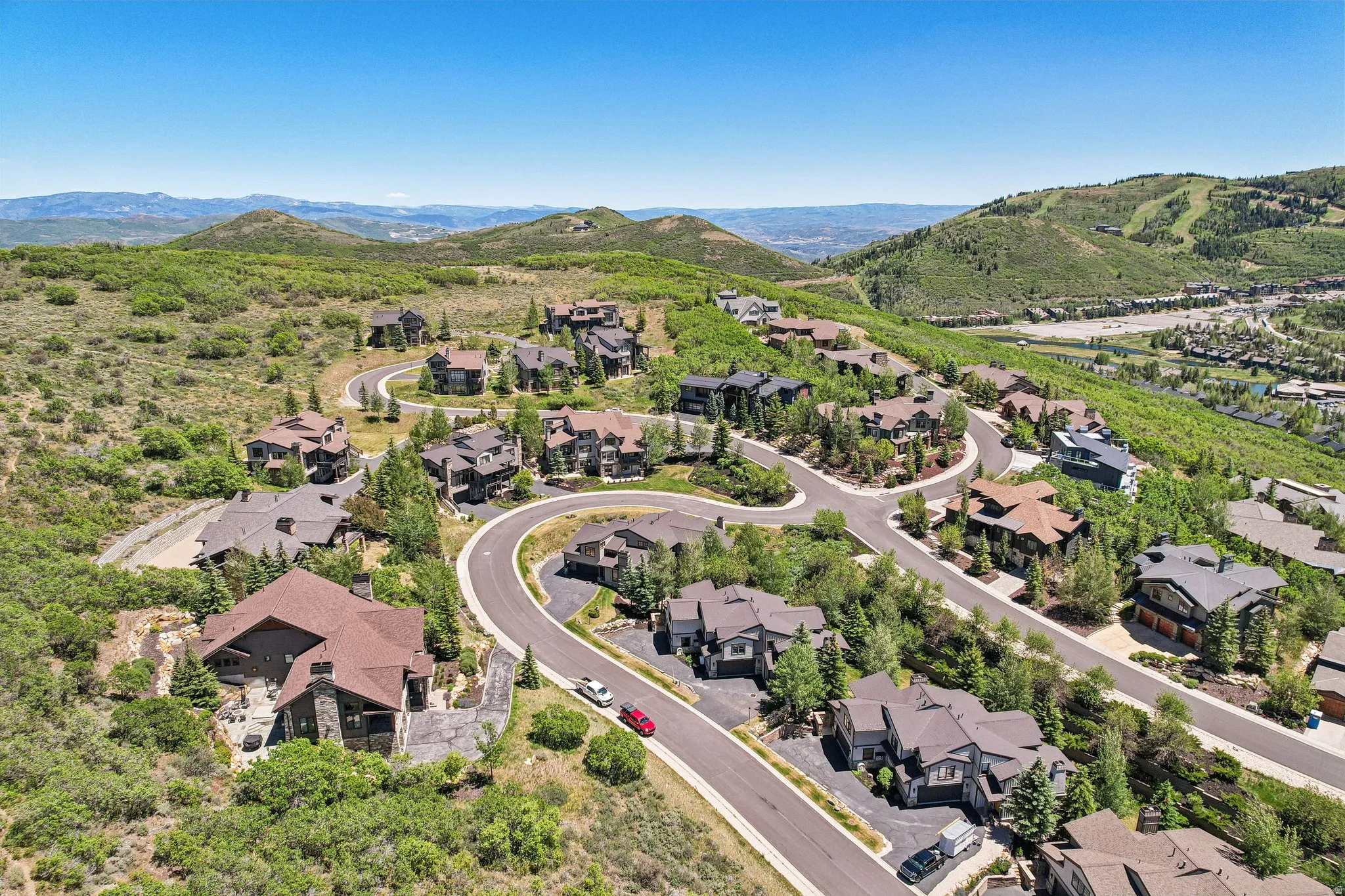 Aerial perspective showcasing a residential community nestled among rolling, verdant hills