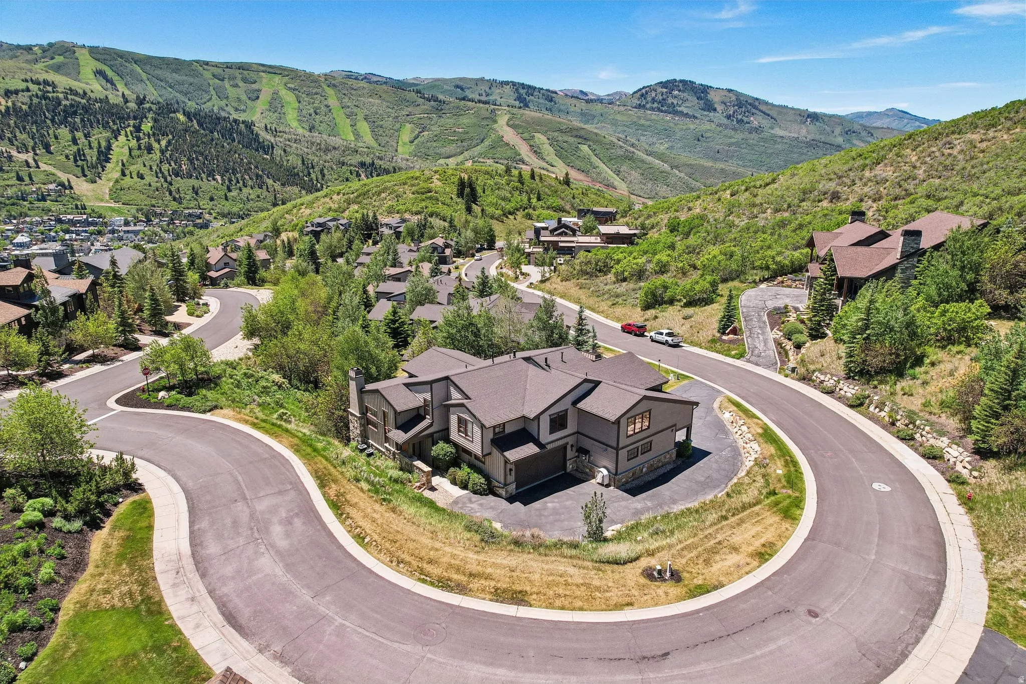 Modern residential structure with a multi-gabled roof, stone accents, and an attached garage
