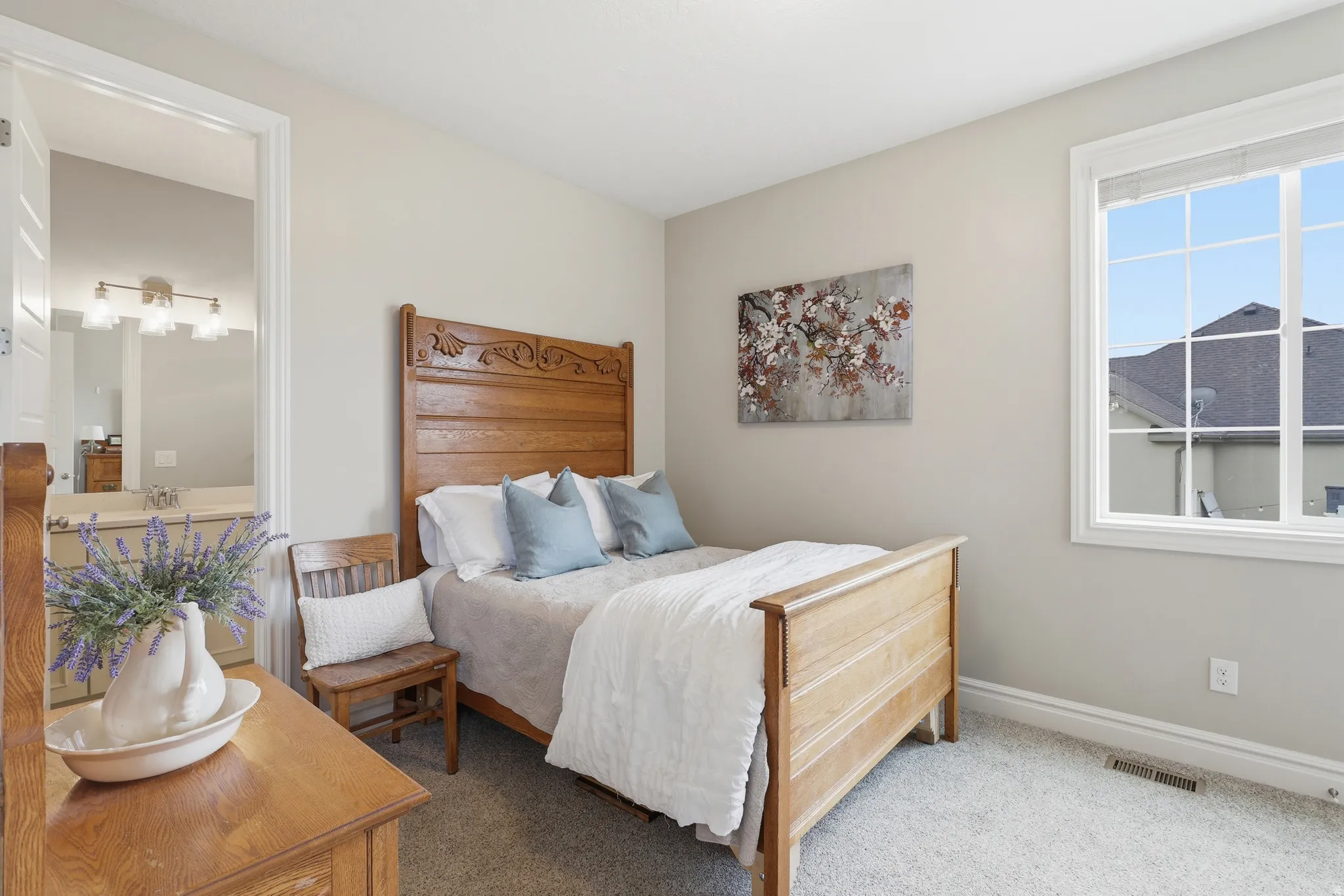 Carpeted bedroom with a single window featuring grid panes and white trim