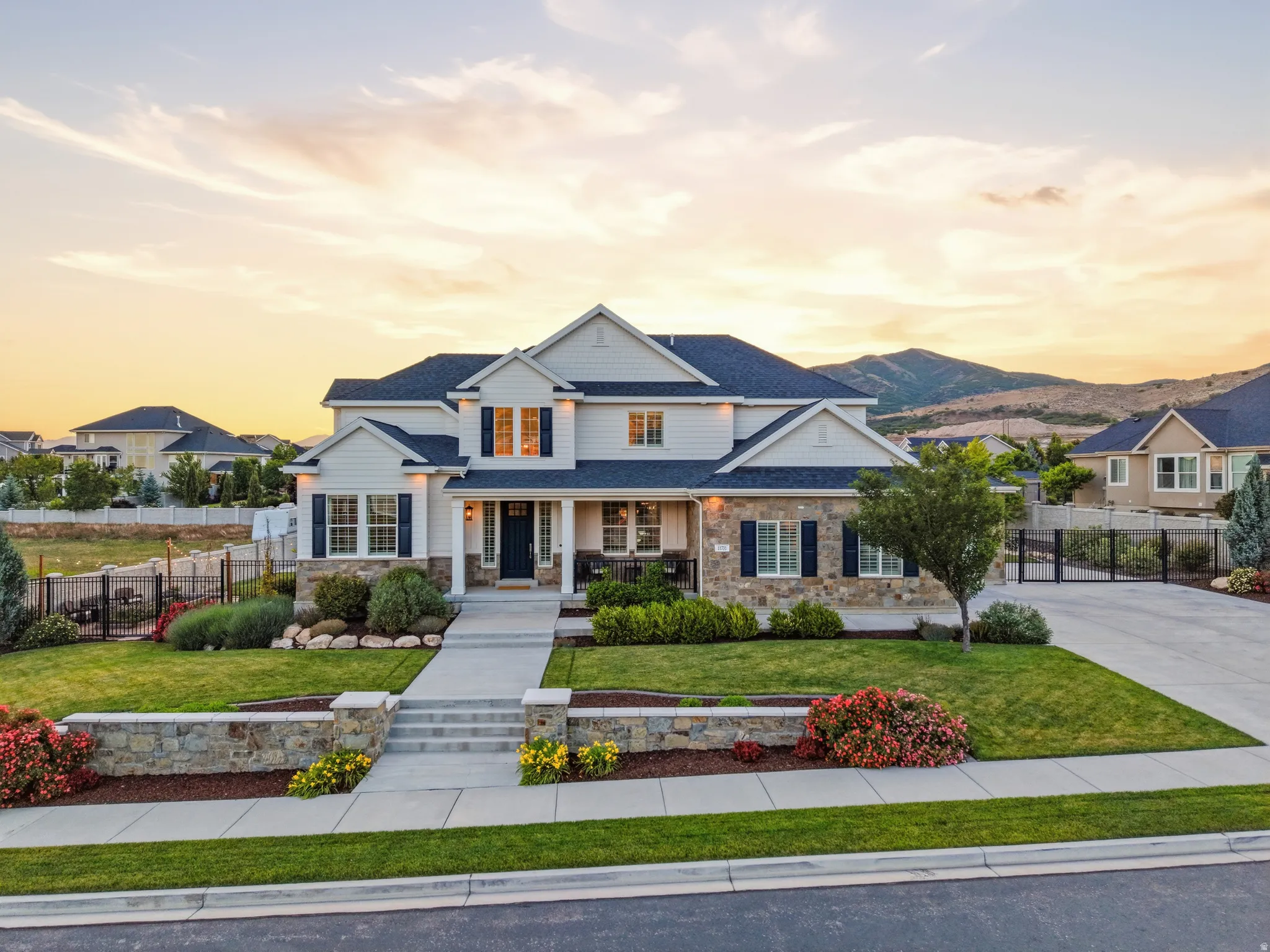 Modern Colonial-style residence featuring a prominent stone facade, white siding, and dark blue shutters