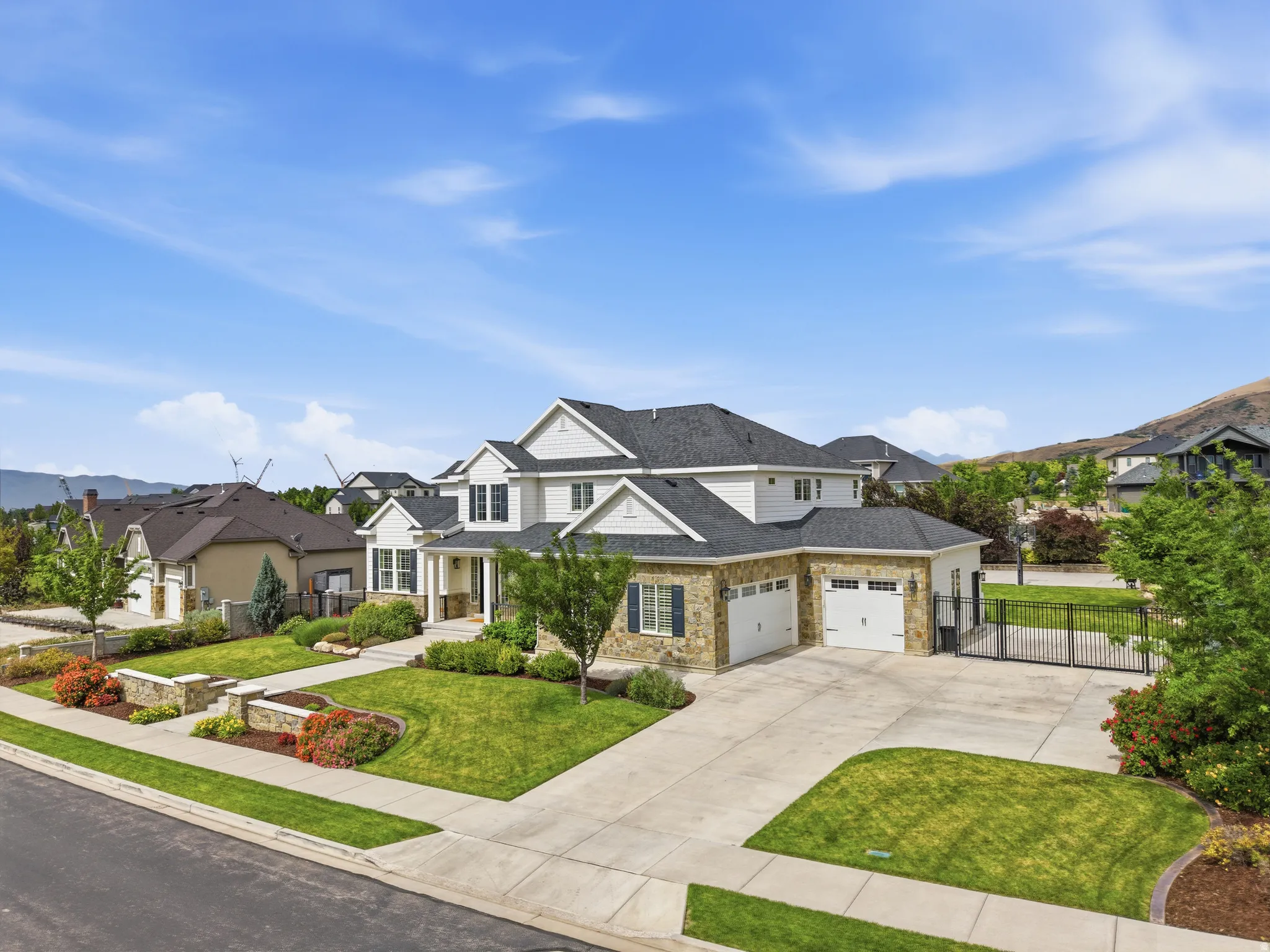 Two-story residence featuring a stone and siding exterior, multiple gables, and a three-car garage