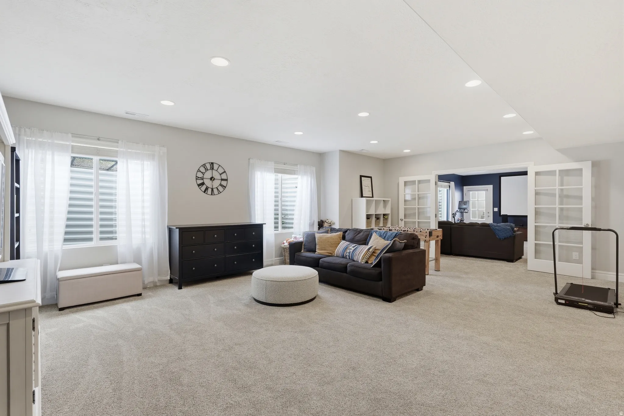 Spacious lower-level area with light-colored carpeting and recessed lighting