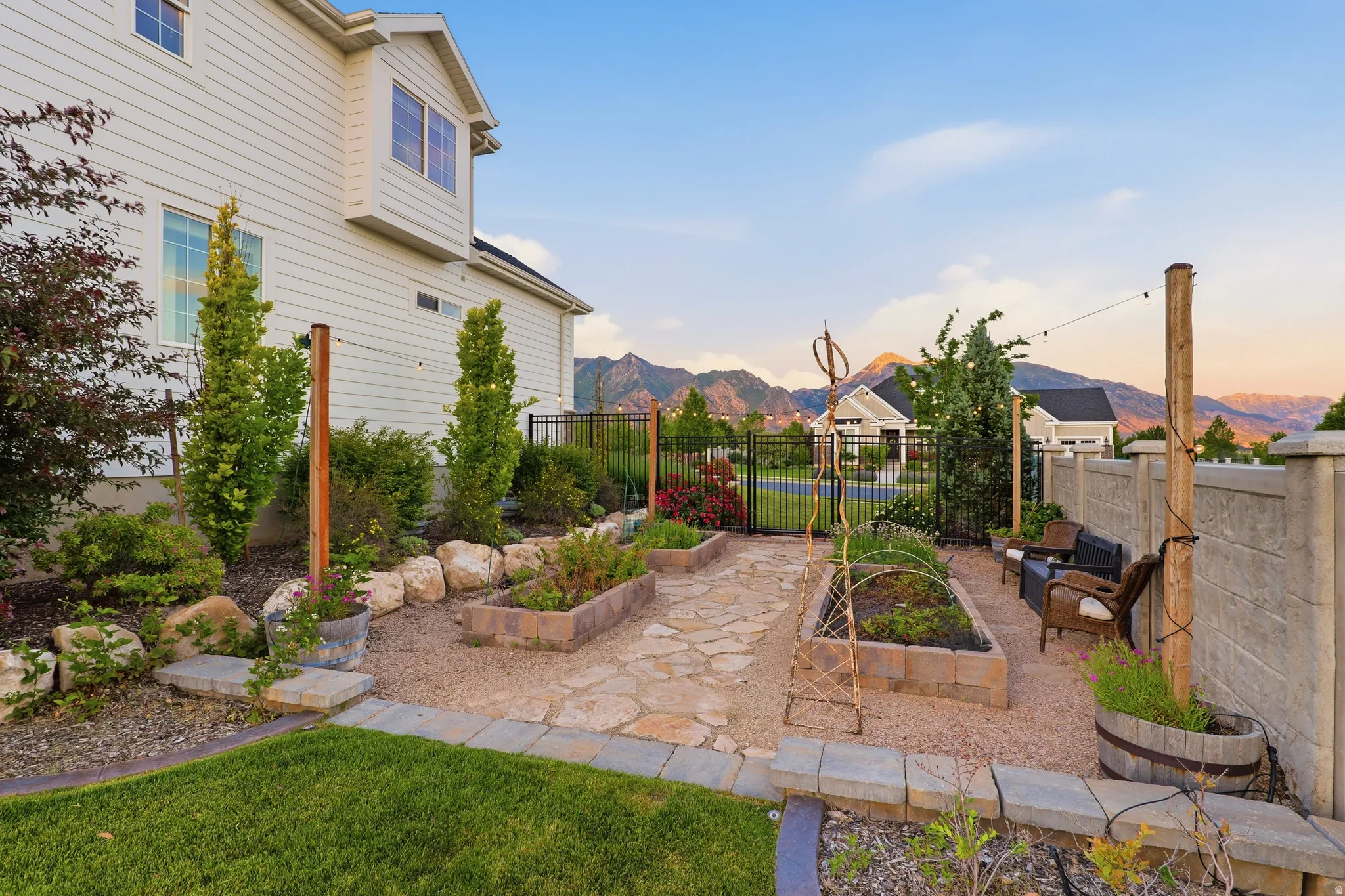 Expansive backyard featuring a manicured lawn, established landscaping, and a flagstone patio