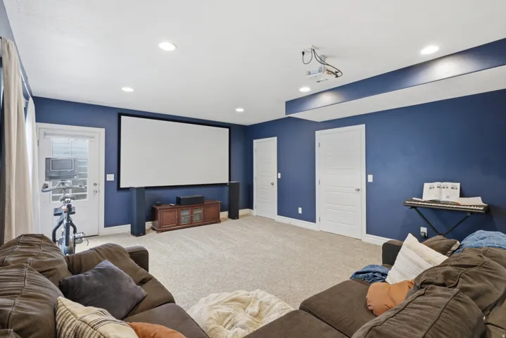 Media room featuring a large projector screen, projector, and recessed lighting