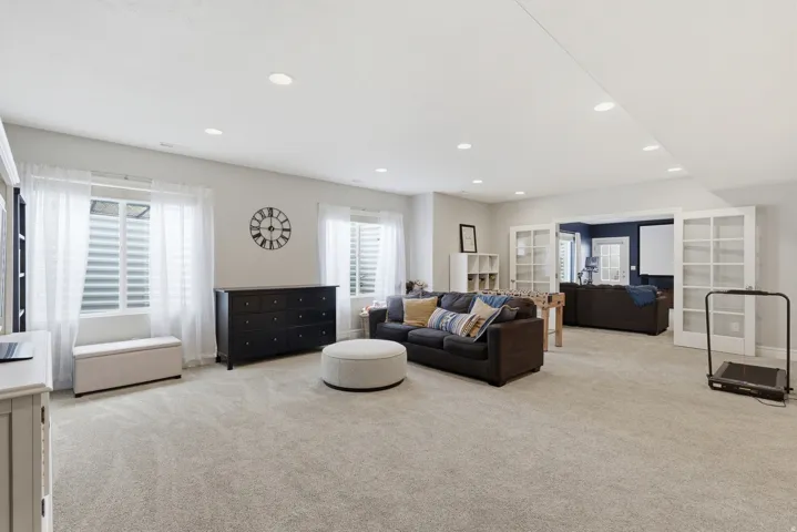 Spacious lower-level area with light-colored carpeting and recessed lighting