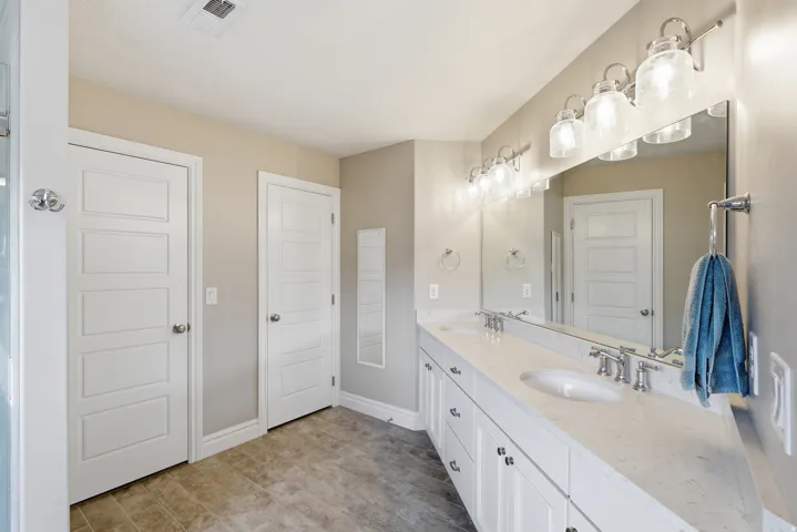 Double vanity featuring white shaker cabinetry, undermount sinks, and light-toned countertops