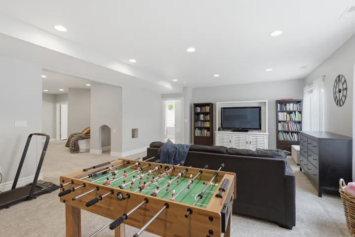 Expansive recreation space featuring recessed lighting, light gray wall tones, and neutral carpet flooring