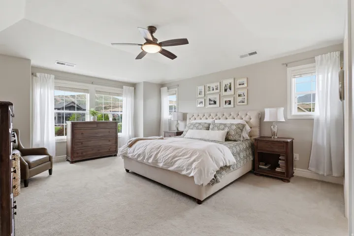 Spacious bedroom featuring vaulted ceilings and neutral-toned wall paint