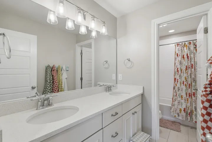 Bathroom featuring a dual vanity with light-colored countertops, undermount sinks, and chrome faucets