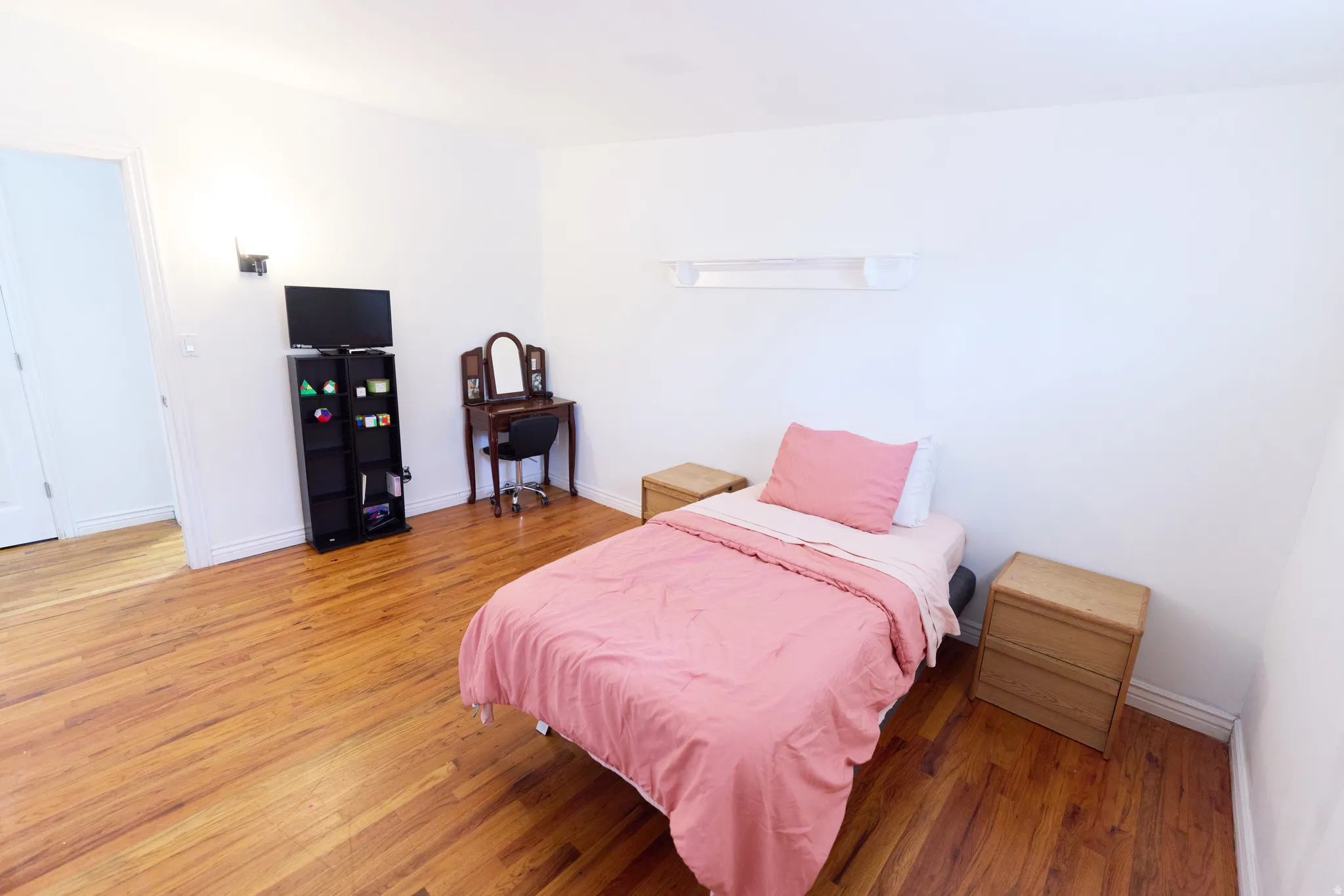 Hardwood flooring throughout this room with white baseboards and walls