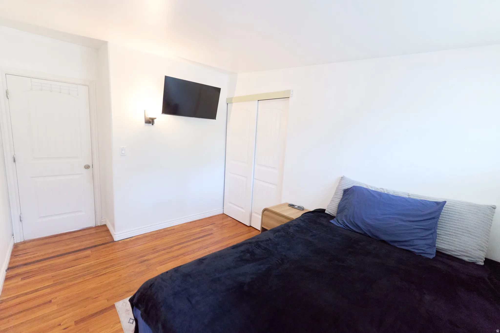 Bedroom featuring hardwood flooring and white baseboards
