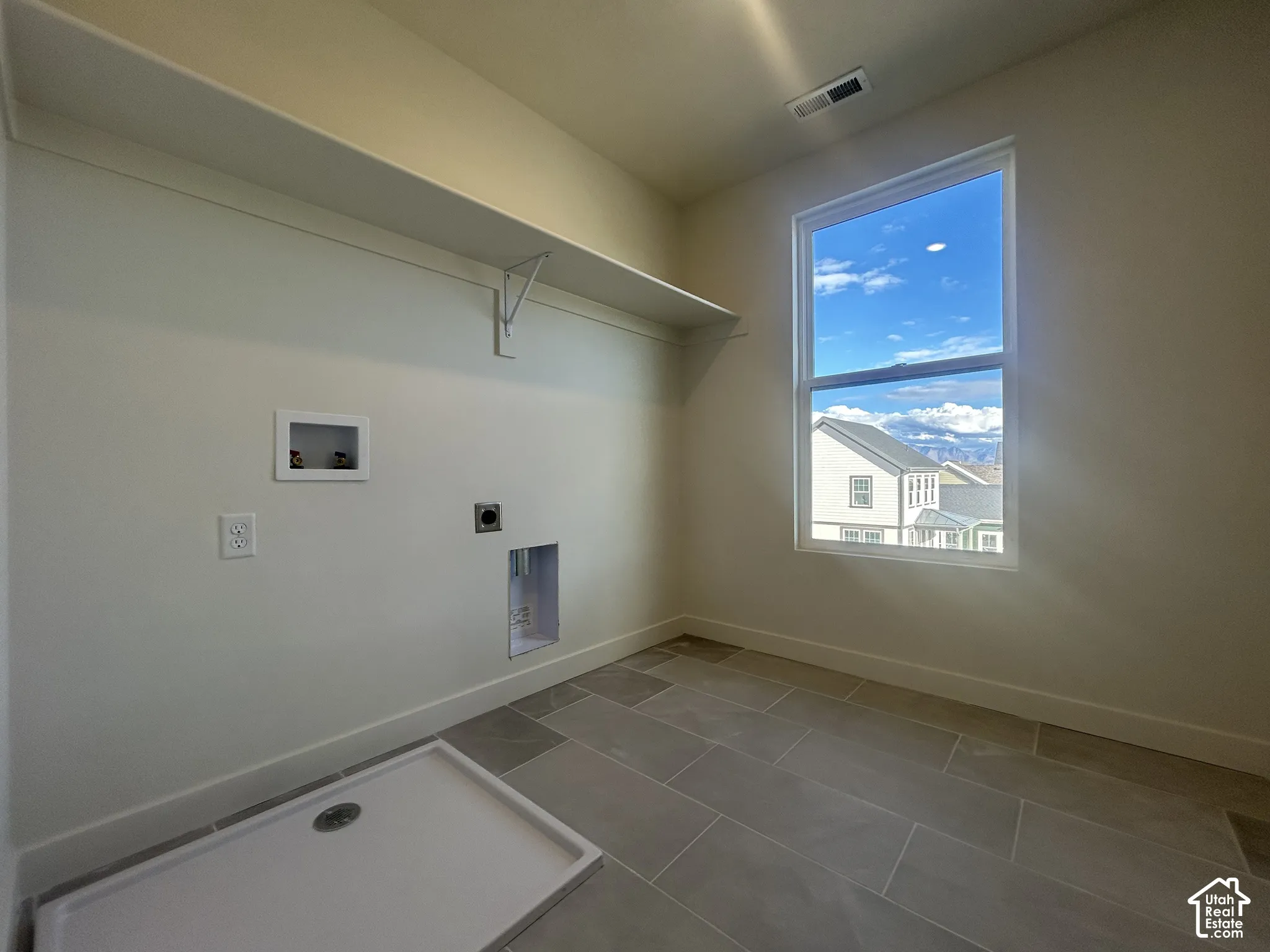 Large-format tile flooring, built-in shelving, and a tall window featuring a mountain backdrop