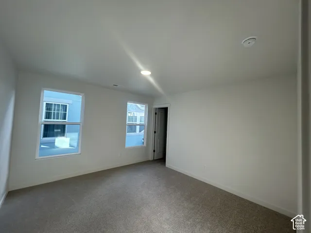 Neutral-toned interior space featuring carpeting, recessed lighting, and two double-pane windows