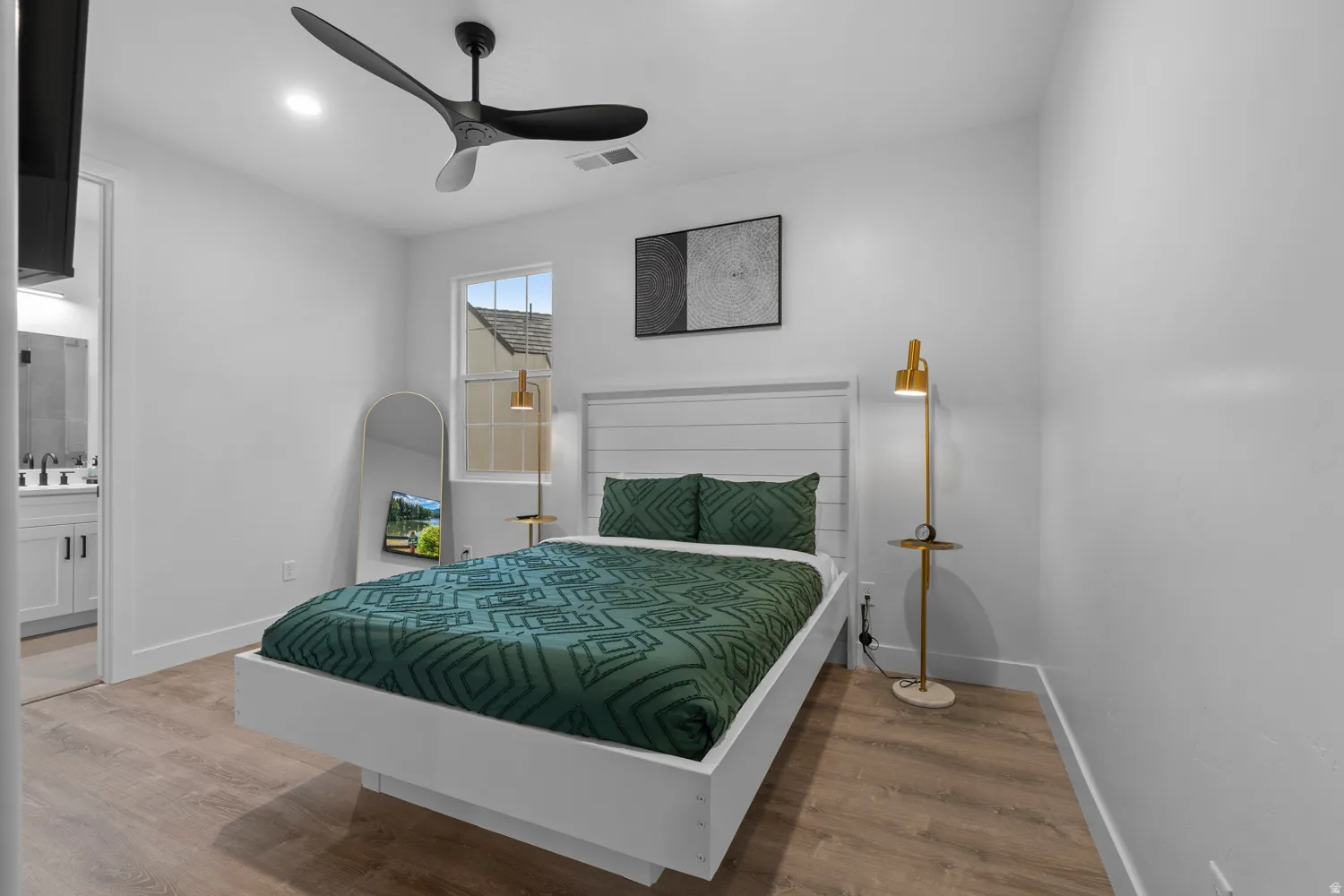 Bedroom with light wood-finish flooring and a contemporary black ceiling fan
